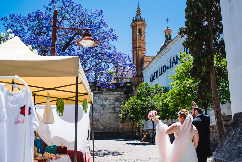 Novios paseando por los alrededores del castillo de san jorge junto al puente de triana y el rio guadalquivir fotografiado por Bodas con Arte