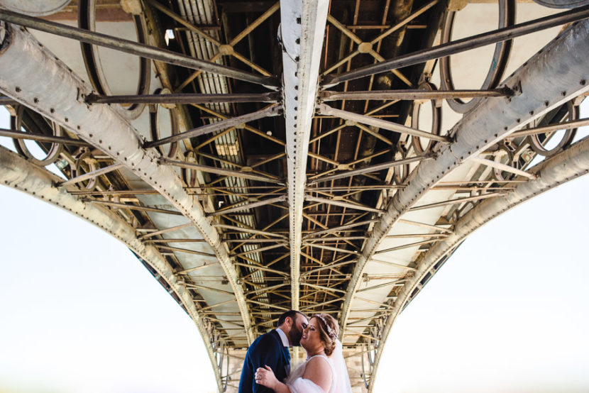 Pareja de novios besandose bajo el puente de Isabel II (Puente de Triana). Foto por Bodas con Arte, Fotógrafos de bodas en Sevilla