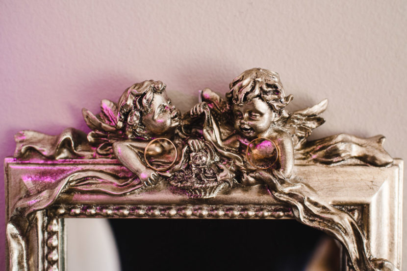 Anillos nupciales sobre marco con dos angelitos. Foto por Bodas con Arte, Fotógrafos de bodas en Sevilla