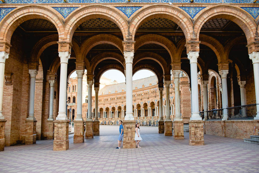 Pareja joven china posando en la Plaza de españa durante su reportaje de preboda. Foto por Bodas con Arte, Fotógrafos de bodas en Sevilla