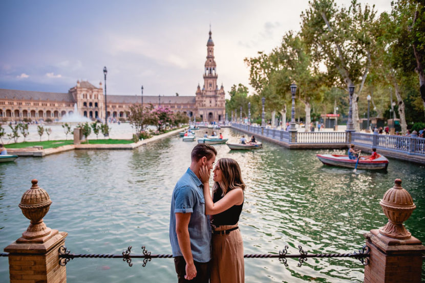 Pareja norteamericana posando en el estanque de la plaza de españa durante su reportaje de compromiso. Foto por Bodas con Arte, Fotógrafos de bodas en Sevilla